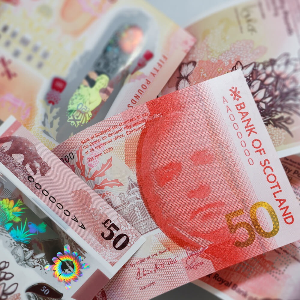 a collection of ornately decorated fifty pound notes from the Bank of Scotland featuring a pine marten